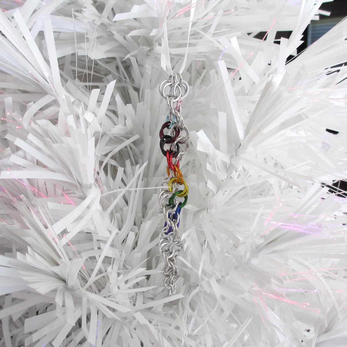 Progress pride flag icicle ornament, handmade chainmail spiral in rainbow, trans, and BIPOC colors